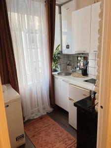 a kitchen with white cabinets and a sink at Cozy apartment in Tallinn Old Town, great location in Tallinn