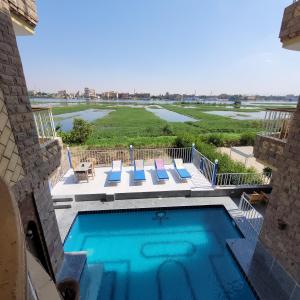a swimming pool with a view of a golf course at Blue Nile House in Luxor