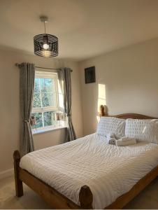 a bedroom with a large bed with a window at Cosy double room with private bathroom homestay in Caldecote