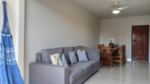 ein Wohnzimmer mit einem grauen Sofa und einem Tisch in der Unterkunft Apto a 3 minutos Praia da Pontinha na Lagoa de Araruama in Araruama