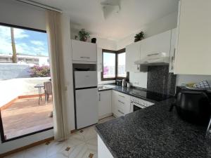 エステポナにあるVillacana 2704の白いキャビネット付きのキッチン、パティオの景色を望む