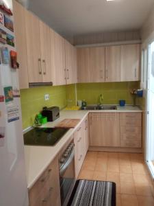 uma cozinha com armários de madeira e um frigorífico branco em Cal Turuta em Vilanova i la Geltrú