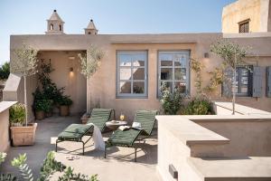 un patio avec des chaises et une table dans un bâtiment dans l'établissement AZADE Chania, à La Canée