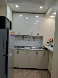 a kitchen with white cabinets and a stainless steel refrigerator at Two-Bedroom Apartment in Tbilisi in Tbilisi City