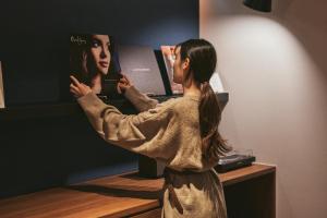 Uma mulher está a olhar-se ao espelho. em Good Ol' Days Hotel em Busan
