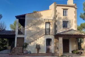 Una casa blanca con una escalera en el lateral. en Villa de 240 m2 au calme avec piscine, en Salon-de-Provence