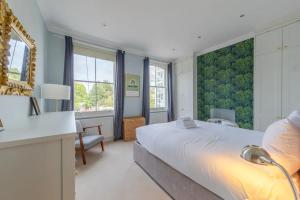 a bedroom with a large bed and a desk at Stylish 2 Bedroom Home in Islington with Garden in London