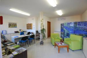 una oficina con sillas verdes, mesa y escritorio en Residence Il Borgo en Tortoreto