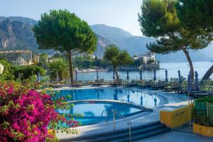 a swimming pool with a view of the water and mountains at Hôtel Vacances Bleues Delcloy in Saint-Jean-Cap-Ferrat