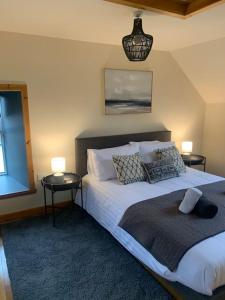 a bedroom with a bed with two tables and two lamps at Orkney Staycations - Orcadale in Orkney