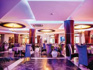 ダル・エス・サラームにあるPeninsula Hotel Dar Es Salaamのダイニングルーム(テーブル、椅子、シャンデリア付)