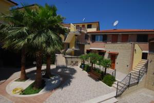 a courtyard with palm trees and a building at Residence Il Borgo in Tortoreto Lido