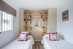 a bedroom with two beds and a mirror and a window at Casa Valentina: Confort y Luz en Sevilla Centro in Seville