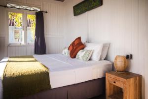 The High Dive Gili Gede by Ultimate Resorts في Gili Gede: غرفة نوم بسرير ومخدات ونافذة