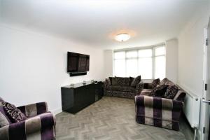 a living room with two couches and a television at Stunning executive style property. in Crosby