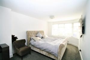 a bedroom with a bed and a chair at Stunning executive style property. in Crosby