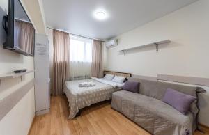 a living room with a couch and a bed at Studiia na Beresteiskoi in Kyiv