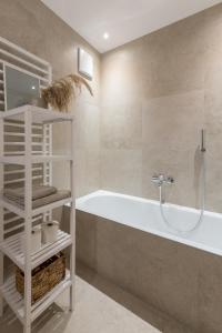 ein Badezimmer mit einer Badewanne und einem Waschbecken in der Unterkunft Ferienwohnung Rosenstrasse in Dornbirn