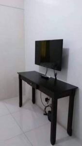 un escritorio negro con un televisor encima en Sea Residences Homey Condo by DNJ, en Manila