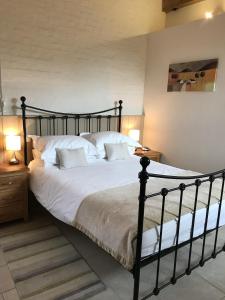 a bedroom with a black bed with white sheets and pillows at Hyde Mill in Luton