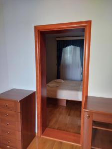 a mirror in a bedroom with a bed and a dresser at Plava Vila Beach Apartments Sveti Stefan in Sveti Stefan