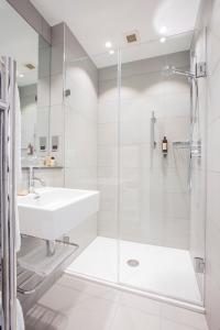 a white bathroom with a sink and a shower at Astor Court Hotel in London