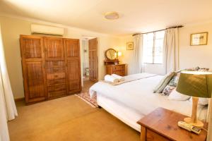 - une chambre avec un lit et une table avec une lampe dans l'établissement Sunbird Cottage, à Graaff-Reinet