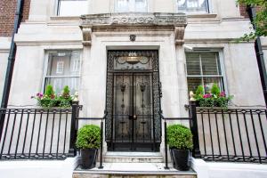 a black door on a building with potted plants at Astor Court Hotel in London