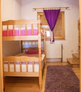 a bedroom with two bunk beds and a purple curtain at Holiday Home Green in Rakovica