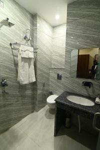 a bathroom with a sink and a toilet and a mirror at The Abhyudyam Ganga in Haridwār