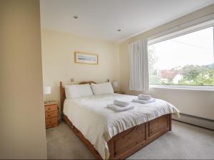 a bedroom with a large bed with two towels on it at Hollycombe Cottage in Wootton Fitzpaine