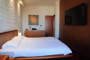 a bedroom with a white bed with a flat screen tv at Stanza in Appartamento incantevole con camino Adelfia Bari in Adelfia