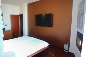 a bedroom with a bed and a tv on a wall at Stanza in Appartamento incantevole con camino Adelfia Bari in Adelfia