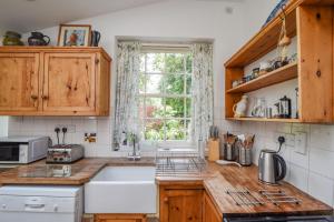 a kitchen with a sink and a window at Greystones Cottage in Chideock