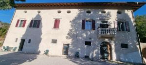 a large white building with red windows and a balcony at Maso kreuzberg- Monolocale 3- vista montagne in Trento