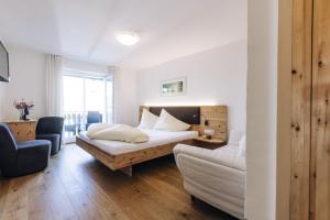 um quarto de hotel com uma cama e um sofá em Amplatz 1523 - B&B and Suites em Montagna