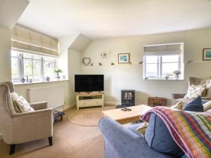 a living room with a couch and a tv at East Barn in Wootton Fitzpaine