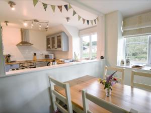 a kitchen and dining room with a wooden table and chairs at East Barn in Wootton Fitzpaine