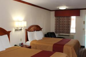 a hotel room with two beds and a window at Sanger Inn in Sanger