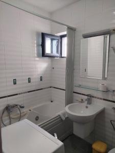 a white bathroom with a tub and a sink at Plava Vila Beach Apartments Sveti Stefan in Sveti Stefan