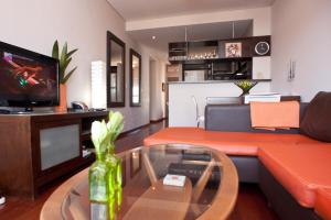 a living room with an orange couch and a glass table at Apartment Santa Fe Plaza in Buenos Aires
