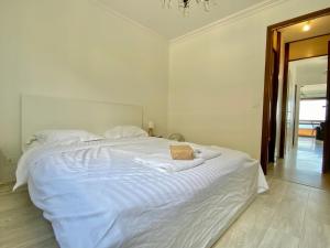 ein Schlafzimmer mit einem weißen Bett mit einer Tasche darauf in der Unterkunft "La Cuse" Vue Mer Imprenable, Calme, Parking in Menton