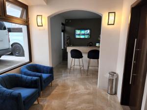 a living room with two blue chairs and a kitchen at L'Aurora Inn in Guatemala