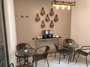 una habitación con mesas y sillas y una cafetera en la pared en L'Aurora Inn en Guatemala