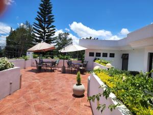 L'Aurora Inn في غواتيمالا: فناء به طاولات ومظلات على المنزل