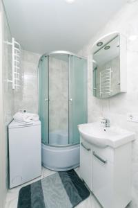 uma casa de banho com uma cabina de duche em vidro e um lavatório. em Studiia na Beresteiskoi em Kiev