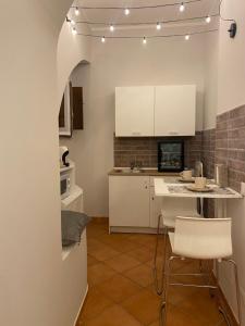 een keuken met witte kasten en een tafel en stoelen bij Saffi58 Holiday Home in Viterbo