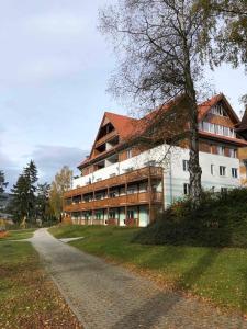 a large building with a tree next to a road at APARTMÁN RIVIÉRA LIPNO 511-16 in Lipno nad Vltavou