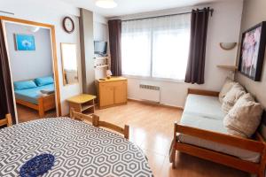 una camera con letto, divano e specchio di Meritxell Pedrous a Pas de la Casa
