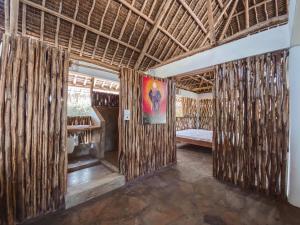 a room with bamboo walls and a bed in it at Villa Samawati - Rafiki Village in Watamu